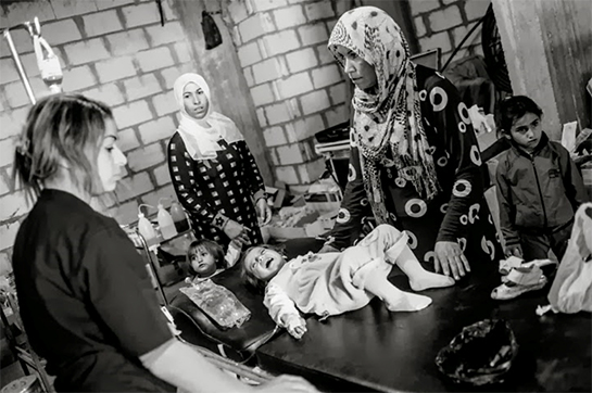 //A young girl receives antibiotics for the flu at a rudimentary clinic in Ra's al-'Ayn. Photo by Younes Mohammad.