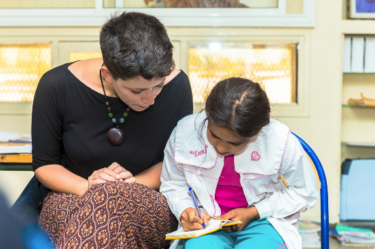 //Luna Roveda, chargée adjointe des services communautaires au HCR à Rabat assurant le soutien scolaire à une fillette syrienne. Sur les 806 enfants syriens âgés entre 6 et 15 ans, 440 sont inscrits à l'école. Parmi eux, la grande majorité va à l'école primaire. MOHAMED DRISSI KAMILI / LE DESK