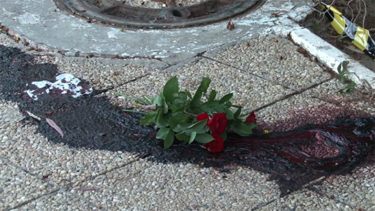 //Une flaque de sang d’une victime sur laquelle un bouquet de fleur a été déposé. Image: Mohamed Haddad