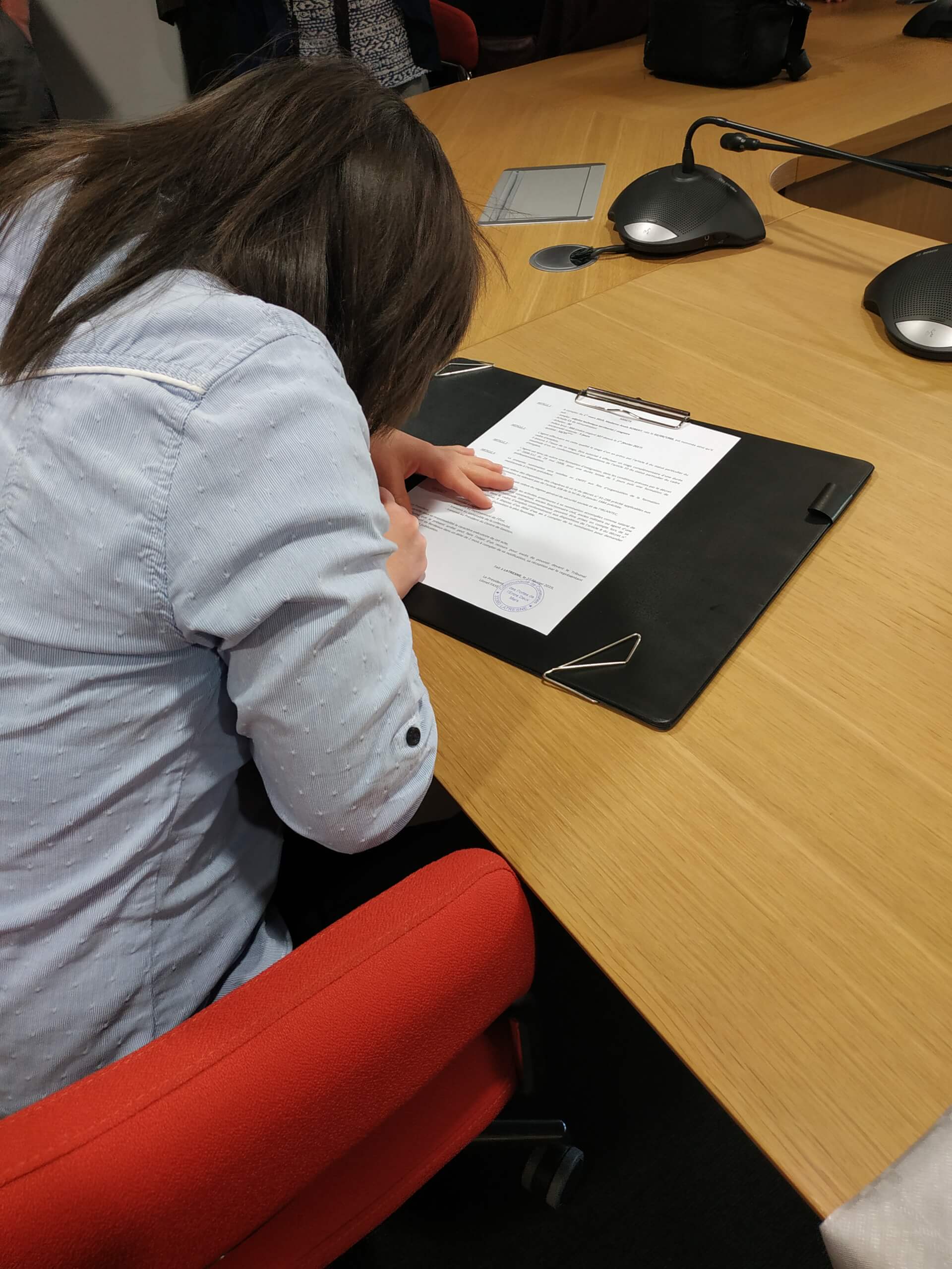 une personne signe un document administratif | Trisomie 21 Nouvelle Aquitaine