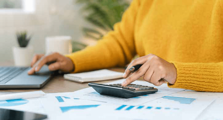 Personne utilisant une calculatrice devant des documents financiers