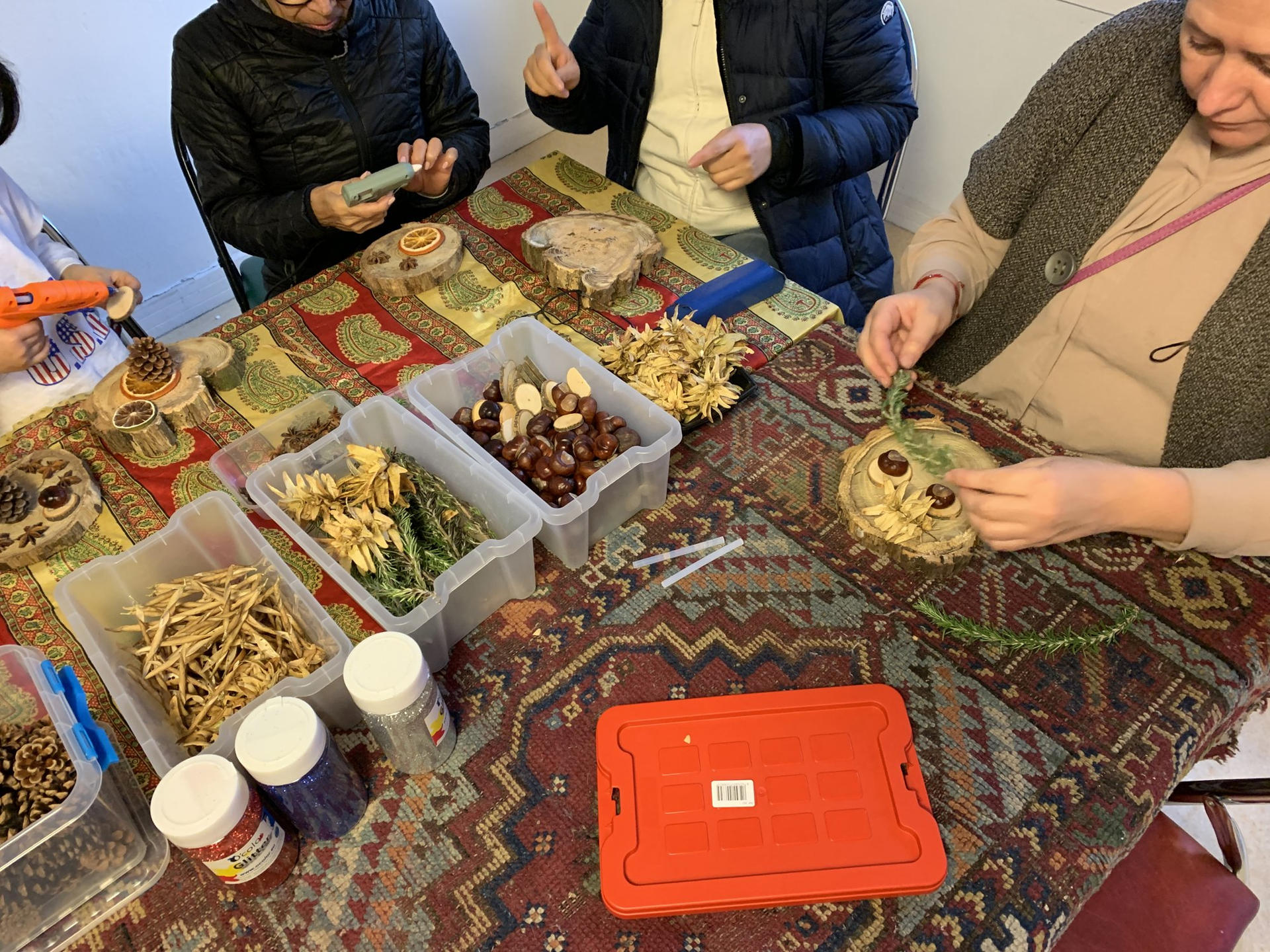 Des participants réalisent une décoration de fête avec des éléments naturels