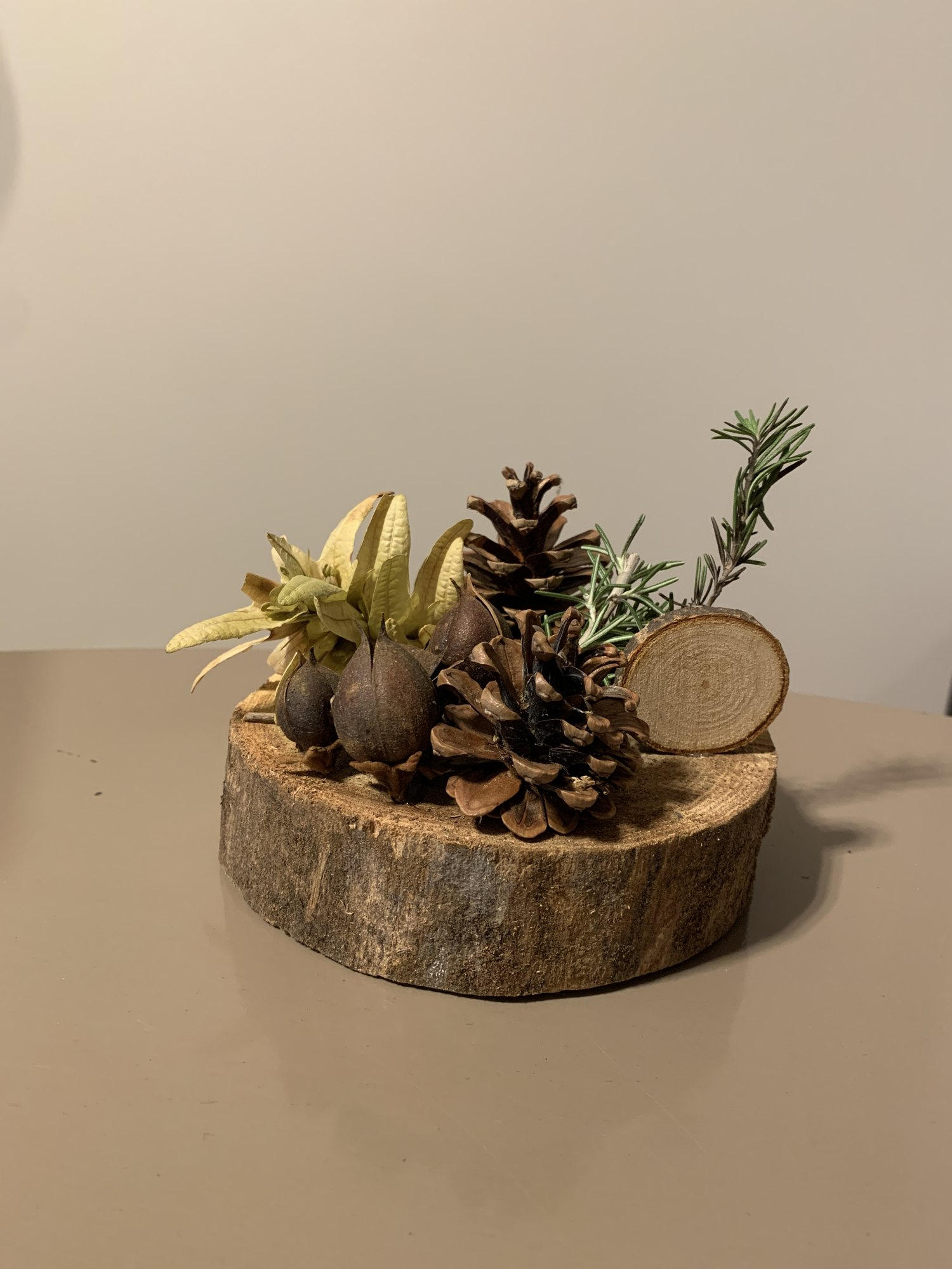 Une décoration de fête en pommes de pin et rondin de bois