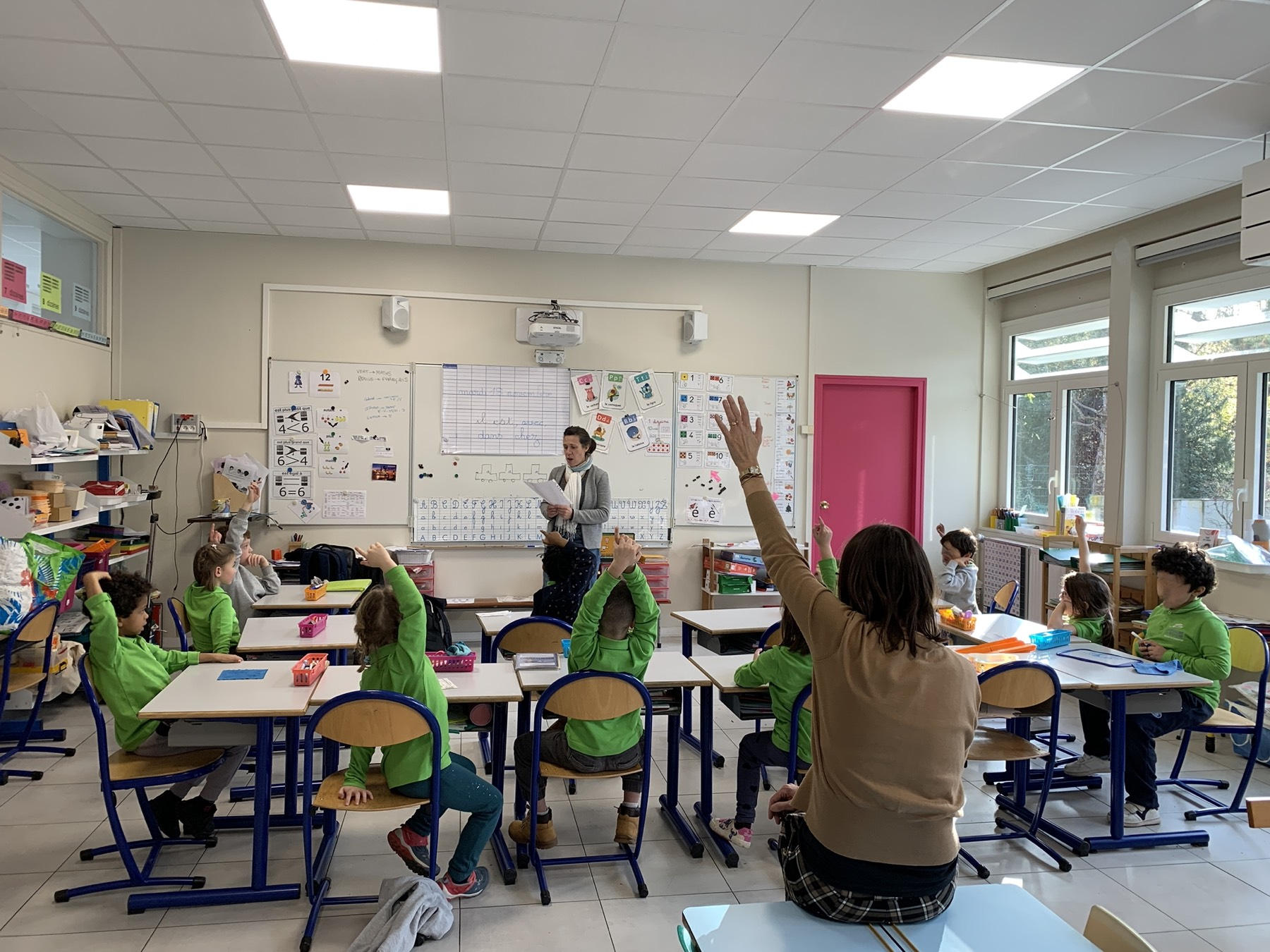 Dans une classe de maternelle, les élèves lèvent la main pour répondre à un quiz sur le plastique