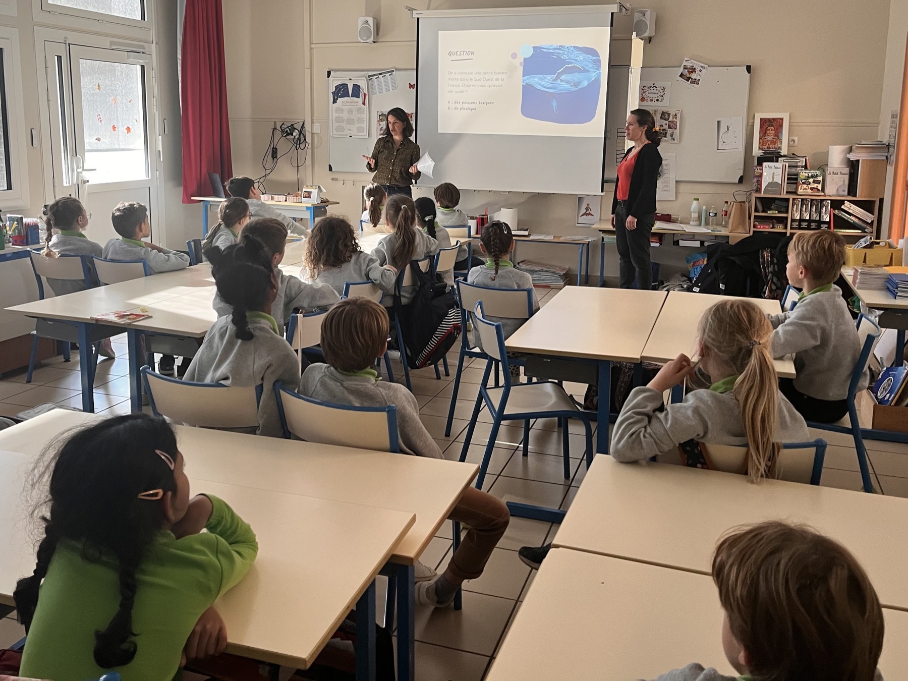 Deux intervenantes présentent un quiz sur le plastique à une classe d'élèves