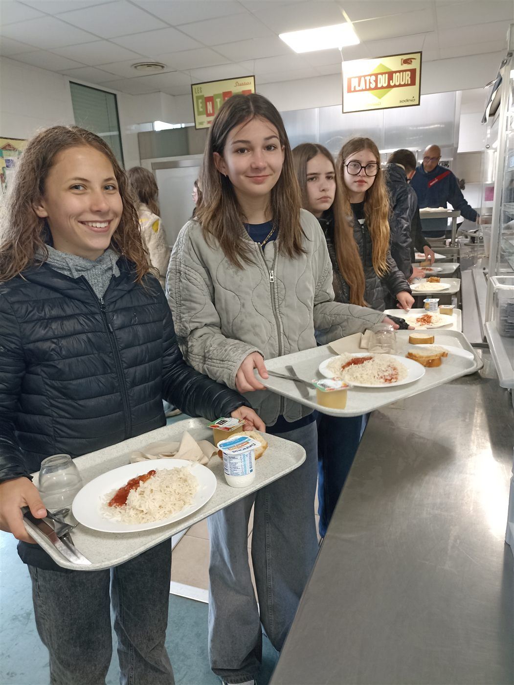 Des collégiennes au self, plateau en main, le jour du Bol de riz