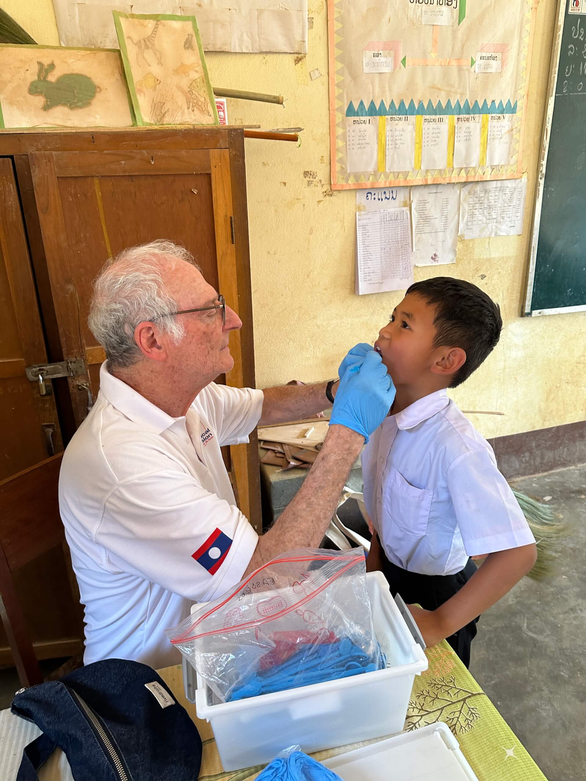 Un soignant bénévole examine un enfant pendant une mission médicale